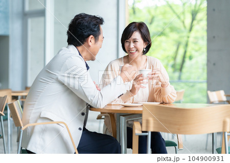 カフェでコーヒーを飲んで会話をする夫婦 104900931