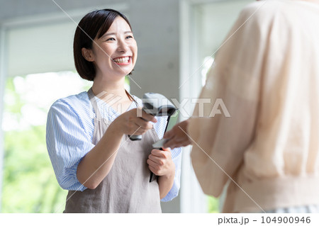 カフェでスマホ決済するミドルの女性と店員 カフェでスマホ決済するミドルの女性と店員 104900946