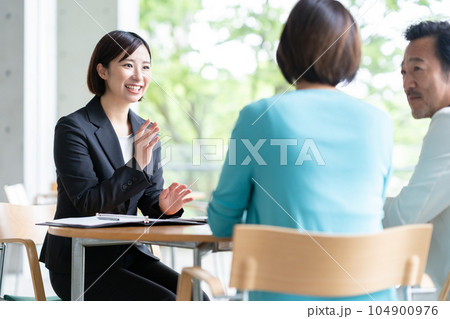 カフェでミドルの夫婦に商談するビジネスウーマン 104900976