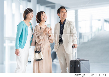 スマホを操作しながら旅行をするミドルの夫婦と娘の家族 スマホを操作しながら旅行をするミドルの夫婦と娘の家族 104901031