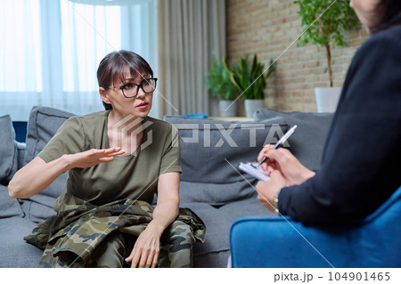 Middle-aged military woman talking with professional psychologist Middle-aged military woman talking with professional psychologist 104901465