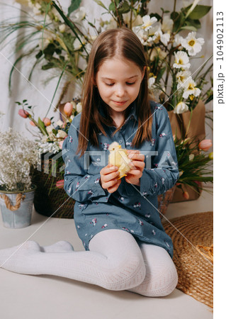 Two girls in a beautiful Easter photo zone with flowers, eggs, chickens and Easter bunnies. Happy Easter holiday. 104902113