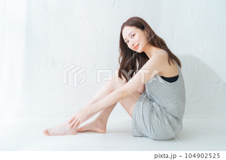 脚のスキンケアとマッサージをする若い女性 脚のスキンケアとマッサージをする若い女性 104902525
