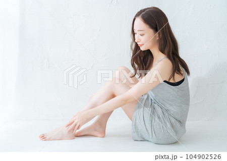 脚のスキンケアとマッサージをする若い女性 脚のスキンケアとマッサージをする若い女性 104902526