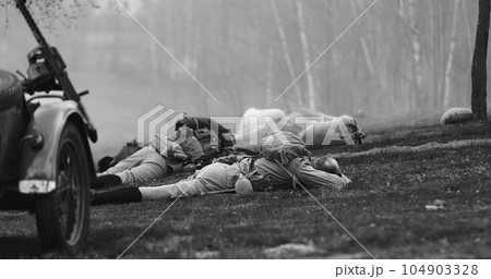 Re-enactor Dressed As Soviet Russian Soldier Lies Slain In Reconstruction Of Battles World War I Near Combat Sidecar. Soviet Russian Infantry Soldier In World War Ii. Black And White Re-enactor Dressed As Soviet Russian Soldier Lies Slain In Reconstruction Of Battles World War I Near Combat Sidecar. Soviet Russian Infantry Soldier In World War Ii. Black And White 104903328