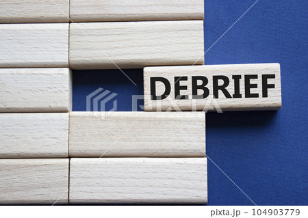 Debrief symbol. Concept word Debrief on wooden blocks. Beautiful deep blue background. Business and Debrief concept. Copy space. 104903779