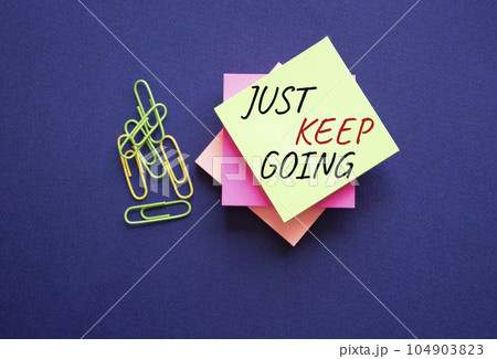 Just keep going symbol. Yellow steaky note with paper clips with words Just keep going. Beautiful deep blue background. Business and Just keep going concept. Copy space. Just keep going symbol. Yellow steaky note with paper clips with words Just keep going. Beautiful deep blue background. Business and Just keep going concept. Copy space. 104903823