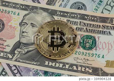 Golden bitcoin coin on a paper dollars money Golden bitcoin coin on a paper dollars money 104904128