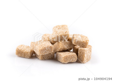 Heap brown sugar cubes isolated Heap brown sugar cubes isolated 104904194