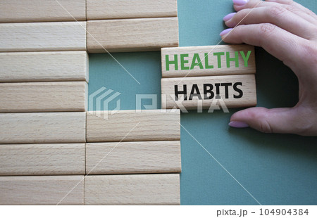 Healthy habits symbol. Concept word Healthy habits on wooden blocks. Businessman hand. Beautiful grey green background. Business and Healthy habits concept. Copy space 104904384