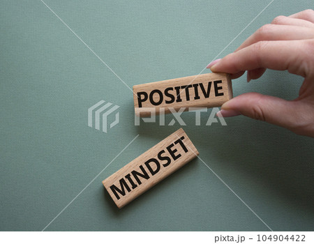Positive Mindset symbol. Concept words Positive Mindset on wooden blocks. Businessman hand. Beautiful grey green background. Business and Positive Mindset concept. Copy space. 104904422