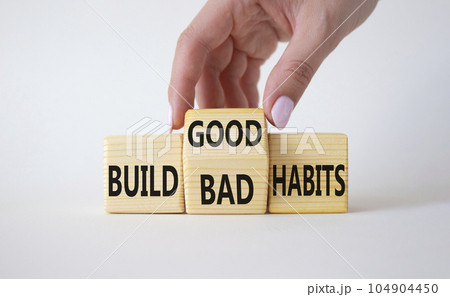 Build Good or Bad Habits symbol. Businessman hand turns wooden cubes and changes the words Build Bad Habits to Build good Habits. Beautiful white background. Business concept. Copy space 104904450