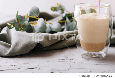 pouring a coffee with milk from teapot to glass cup pouring a coffee with milk from teapot to glass cup 104906233
