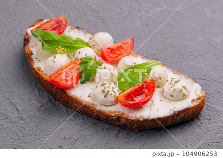 Caprese bruschetta toasts with cherry tomatoes 104906253