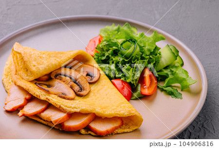 Thin delicious pancake with ham and mushrooms 104906816