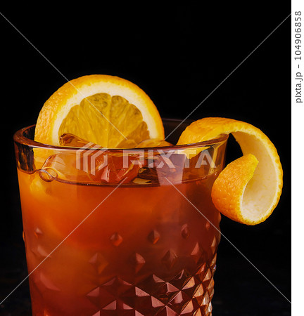 Old-fashioned cocktail with ice and orange peel Old-fashioned cocktail with ice and orange peel 104906858