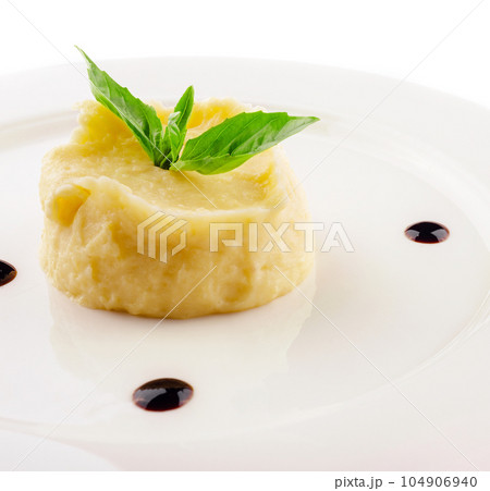 Mashed potatoes and basil on white plate Mashed potatoes and basil on white plate 104906940