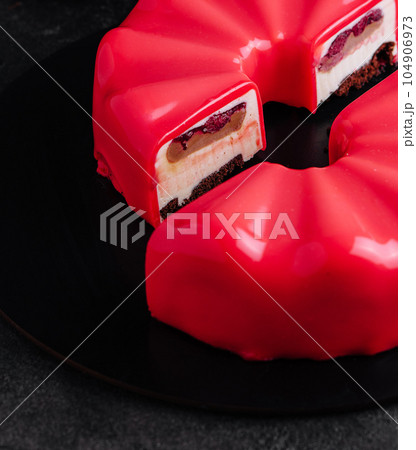 Multi layered raspberry mousse cake on plate 104906973
