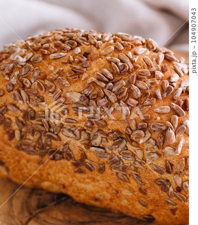 Whole wheat bread with seeds on wood Whole wheat bread with seeds on wood 104907043