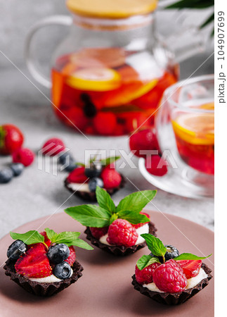 Chocolate ganache tarts with fresh berries Chocolate ganache tarts with fresh berries 104907699