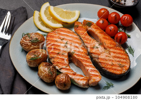 Grilled salmon steaks and potatoes 104908180