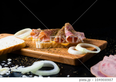 Slices of sausage Mortadella and onion on cutting board Slices of sausage Mortadella and onion on cutting board 104908987