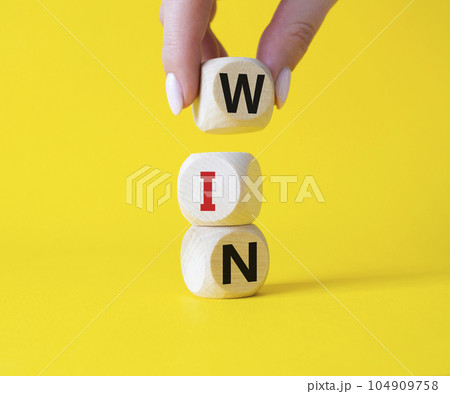 Win symbol. Wooden blocks with words Win. Businessman hand. Beautiful yellow background. Business and Win concept. Copy space. 104909758