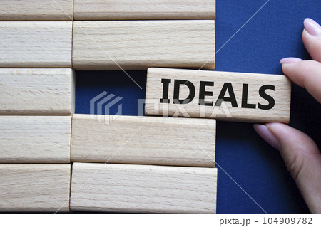 Ideals symbol. Wooden blocks with word Ideals. Businessman hand. Beautiful deep blue background. Business and Ideals concept. Copy space. Ideals symbol. Wooden blocks with word Ideals. Businessman hand. Beautiful deep blue background. Business and Ideals concept. Copy space. 104909782
