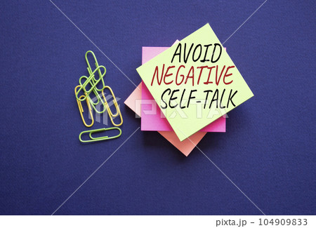 Avoid negative self-talk symbol. Concept words Avoid negative self-talk on yellow steaky note with paper clips. Beautiful deep blue background. Business and Avoid negative self-talk concept. Copy 104909833