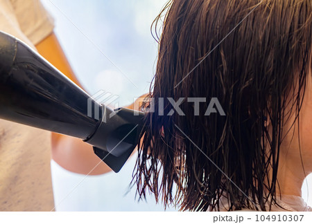 drying hair with a hair dryer at the barbershop 104910307