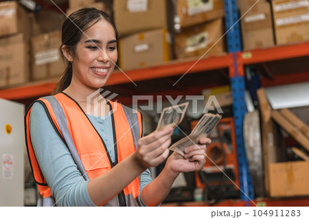 Engineer warehouse staff employee happy glad to recieve salary increase. industry woman worker happy glad with overtime bonus money payday 104911283