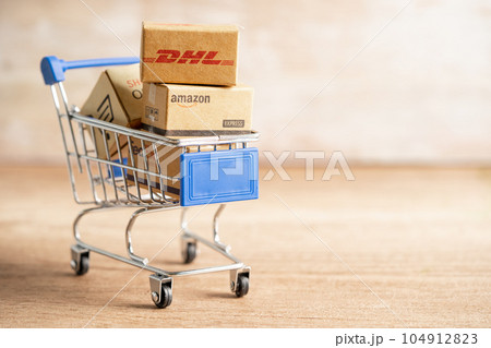 Bangkok, Thailand September 26, 2022 Shopping cart with DHL Amazon and FedEx express packing box, import export online exchange investment business. 104912823