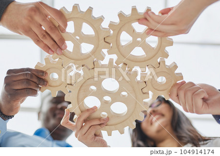 Business people holding wooden gears in the office, bottom view 104914174