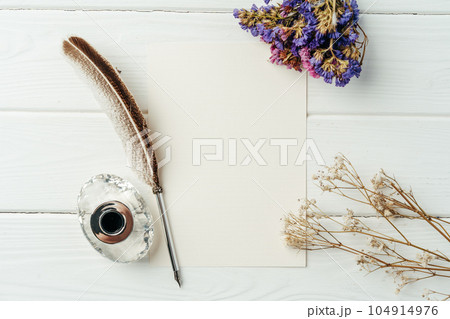 Blank letter, dry flowers and antique feather pen on wooden background 104914976
