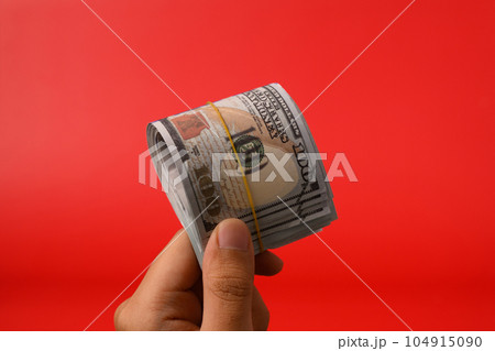 Hand holding hundred dollar bills on red background, Banknotes for money saving, Cash money dollars, Business investment and income, Global financial crisis, Earning and saving money concept Hand holding hundred dollar bills on red background, Banknotes for money saving, Cash money dollars, Business investment and income, Global financial crisis, Earning and saving money concept 104915090