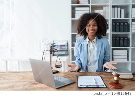 Young African American lawyer studying a case for a client and signing a legal contract to fight her opponent in court. Legal and lawyer concepts Young African American lawyer studying a case for a client and signing a legal contract to fight her opponent in court. Legal and lawyer concepts 104915642