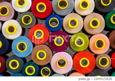 set of multi-colored spools of thread for sewing 104915926