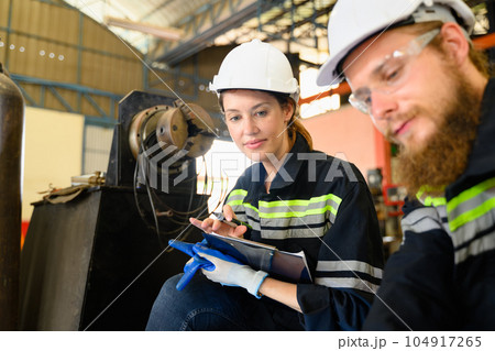 Mechanical engineers repairing engine machine at factory 104917265
