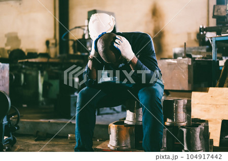 Unhappy and tired male industrial worker with headache 104917442