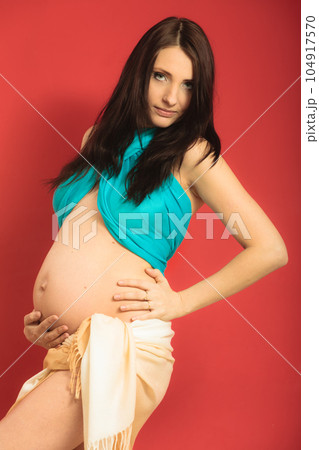 Attractive pregnant woman touching her belly Attractive pregnant woman touching her belly 104917570