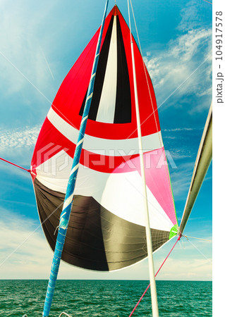 Spinnaker with uphaul, blue sky in background. Spinnaker with uphaul, blue sky in background. 104917578