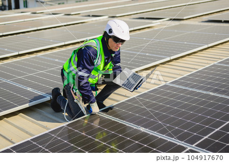 Engineers with safety helmet checking solar system at solar power farm 104917670