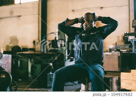 Unhappy and tired male industrial worker with headache 104917682