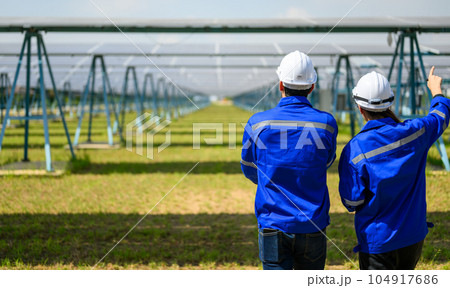 Workers installing solar panels, Engineer team at solar panel farm 104917686