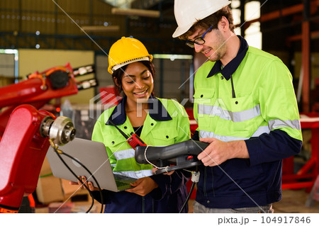 Technician engineer holding robot controller checking and repairing machine 104917846