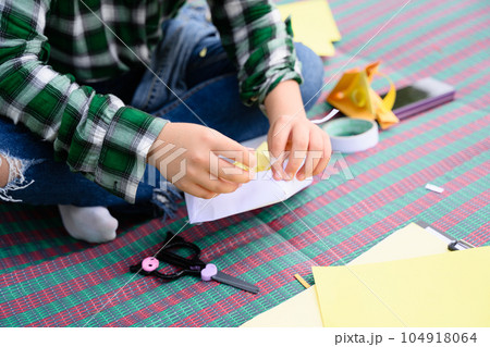 Happy girl making paper toy and playing in garden on weekend 104918064