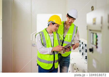 Maintenance engineer maintaining solar panels on solar cell farm 104918072