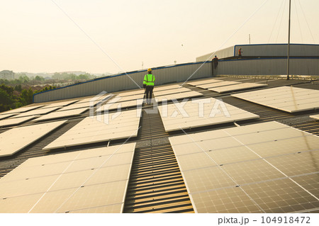 Engineer working at solar cell farm power plant with sunset in evening 104918472