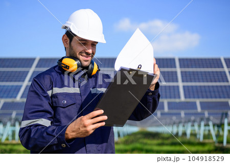 Engineer worker portrait with solar panel at solar farm Engineer worker portrait with solar panel at solar farm 104918529