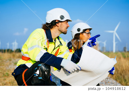 Technicians team with safety uniform working at wind turbine field 104918612